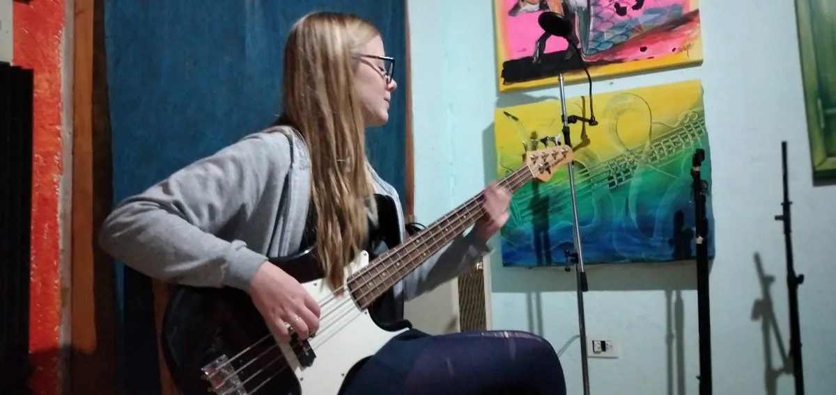 Alumna tocando bajo eléctrico en clases de Notas en Clave, Córdoba